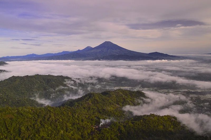 Panorama fajar perbukitan Menoreh Kulon Progo Yogyakarta dengan lanskap gunung dan lembah berawan rute ajang Biosferun