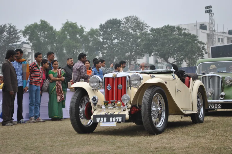 Mobil klasik berjajar di area pameran otomotif dan gerbang rally terbuka diiringi antusiasme pengunjung dan kru teknis