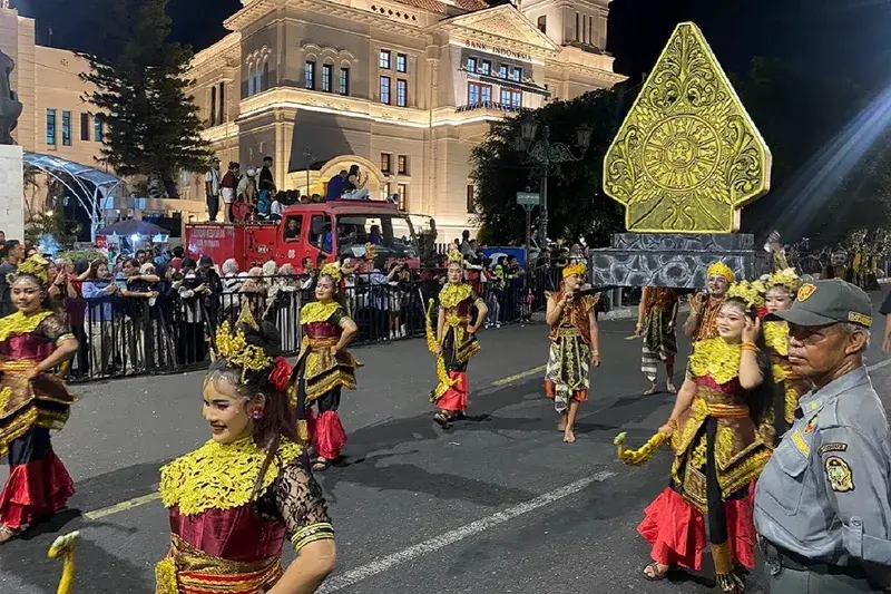 Parade seni tari karnaval Wayang Jogja Night Carnival dengan tata lampu dramatis di kawasan Malioboro